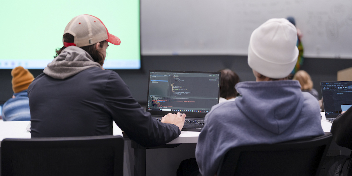 A student works on some code on his laptop during a computer science class.